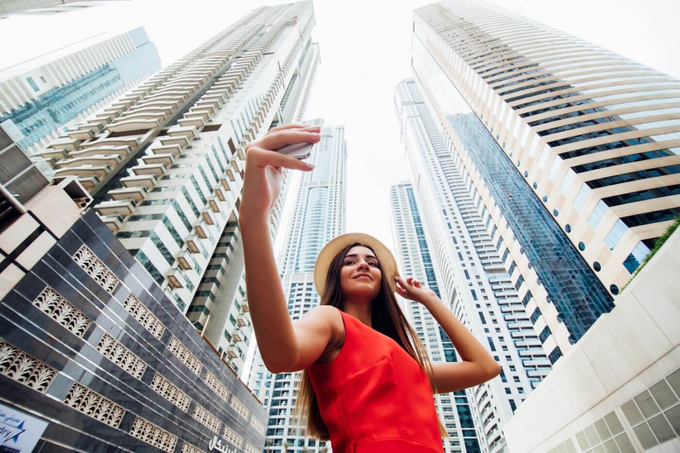 Uśmiechnięta influencerka robi selfie na tle gigantycznych wieżowców w Dubaju. Czy to rajskie życie jest tylko iluzją?